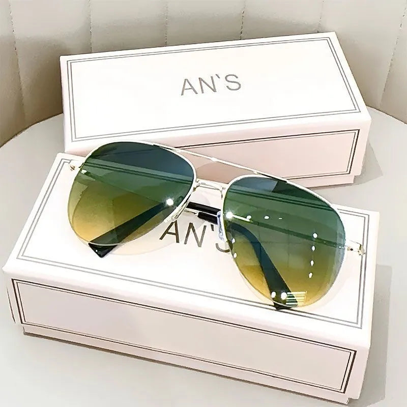Aviator-style sunglasses with a metal frame and tinted resin lens, shown in a gold frame variant.