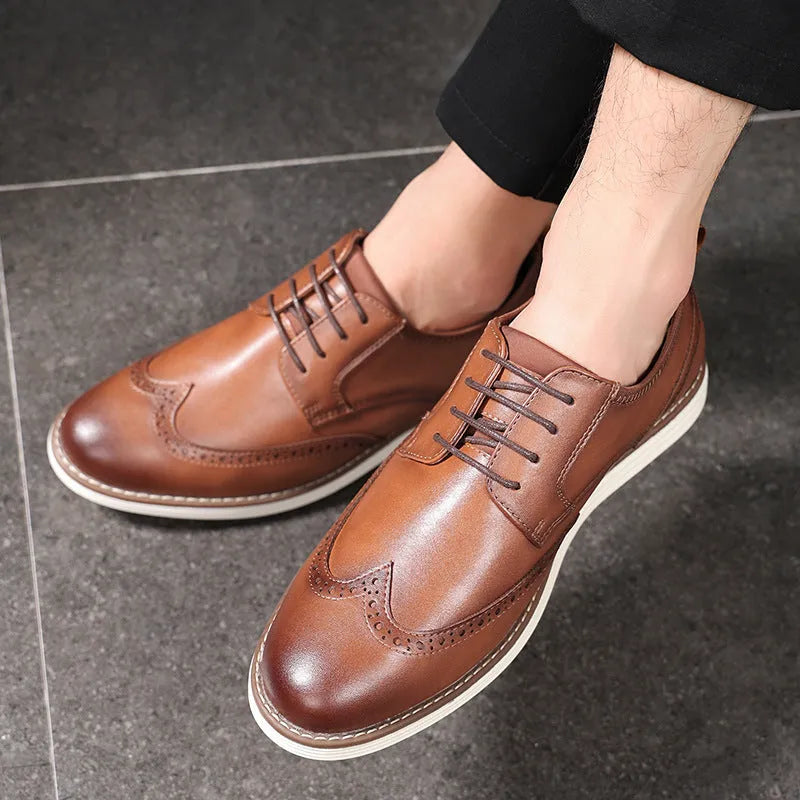 Men's black slip-on business casual shoes with round toe and carved detail on a white background.