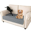 Reversible waterproof dog cushion on a sofa in dark grey and light grey contrast colours.
