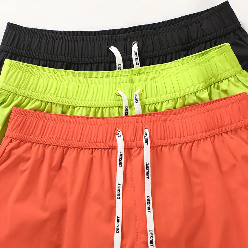 Men's loose beach shorts in orange, fluorescent green and black colours with elastic polyester fabric