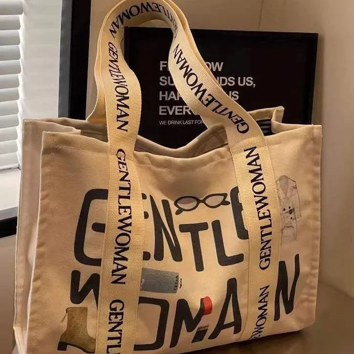 Women's large capacity canvas tote bag with printed design in three colour options.