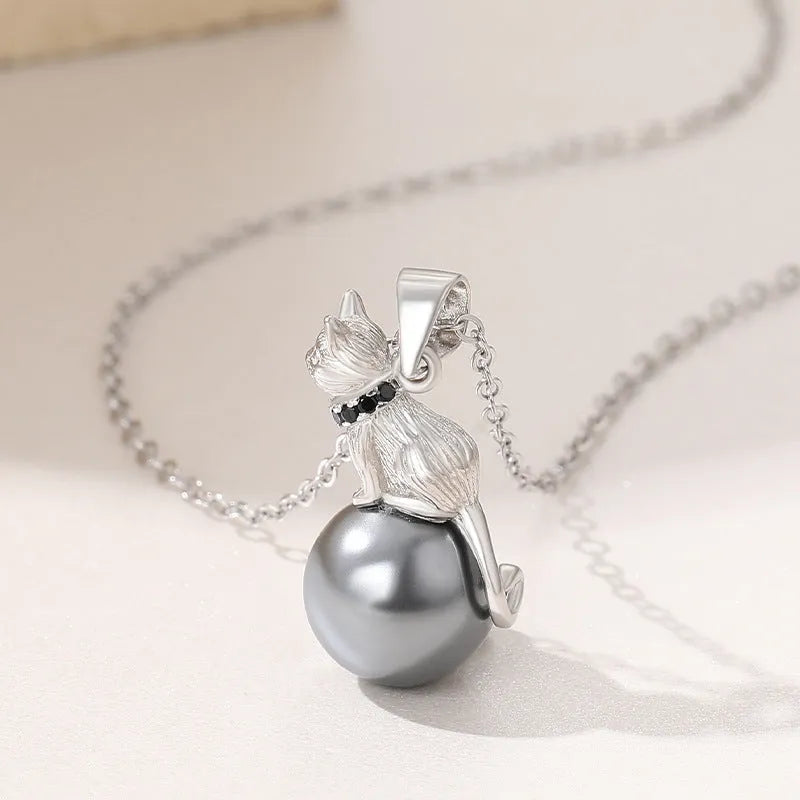 Close-up of a sterling silver cat pendant necklace on a chain with an electroplated finish.