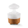 Wood grain white rain cloud shaped humidifier diffuser with LED night light on a table.