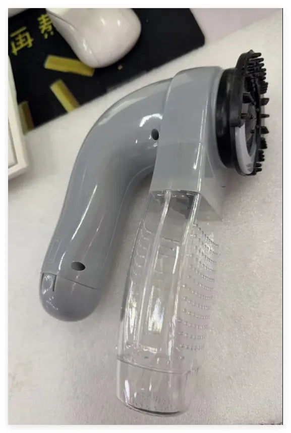 Grey portable electric pet hair vacuum cleaner with soft rubber grooming head.