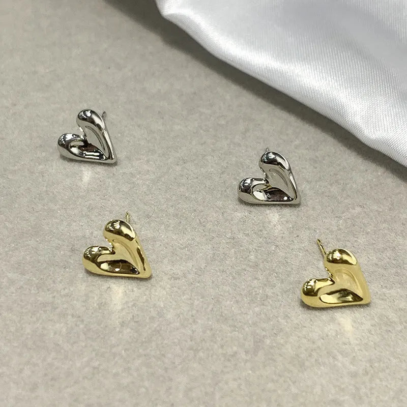 Heart-shaped stud earrings in gold and silvery metal alloy for pierced ears, simple small design