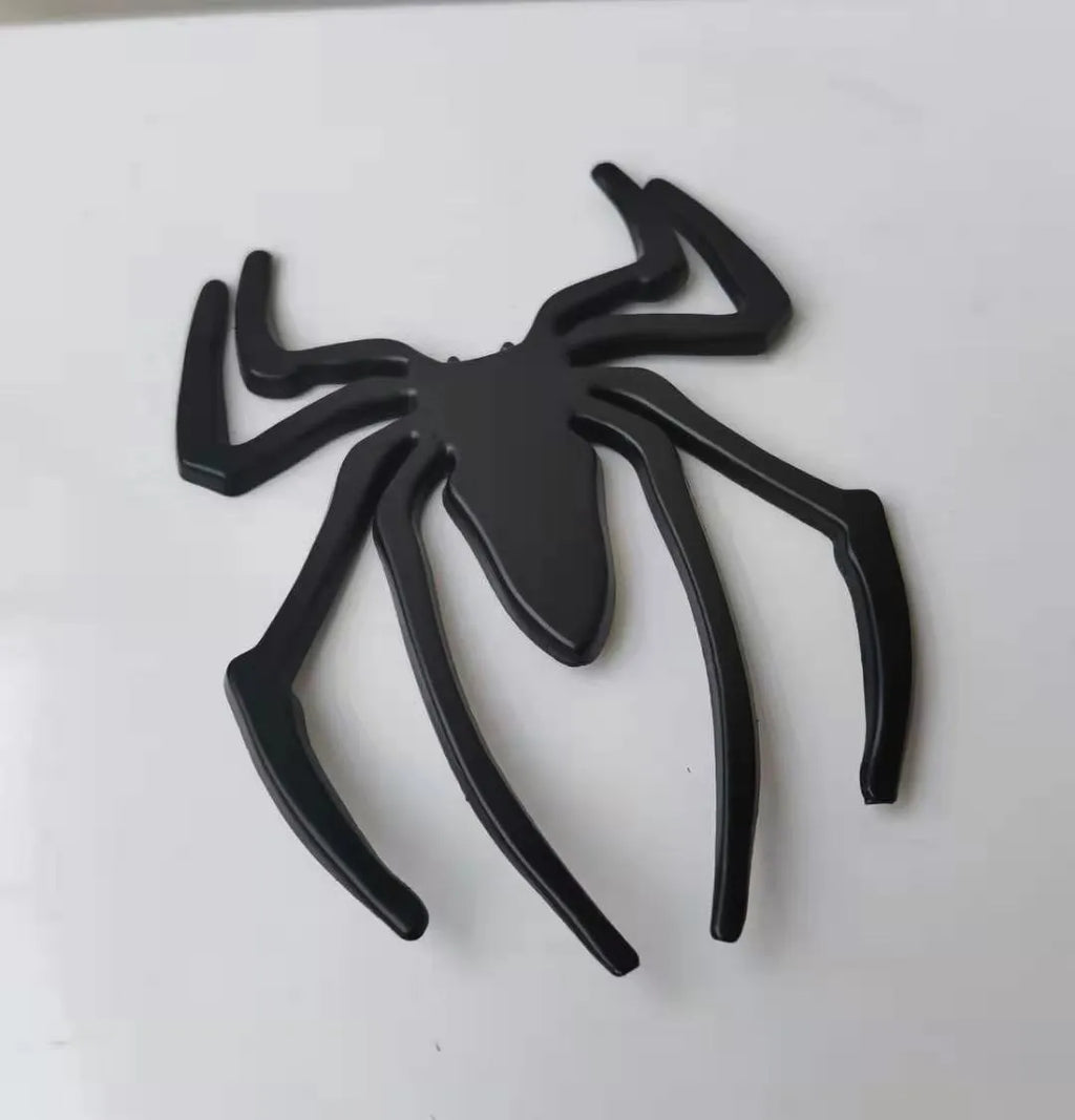 Three-dimensional metal spider bumper sticker in zinc alloy, showing gold colour option.