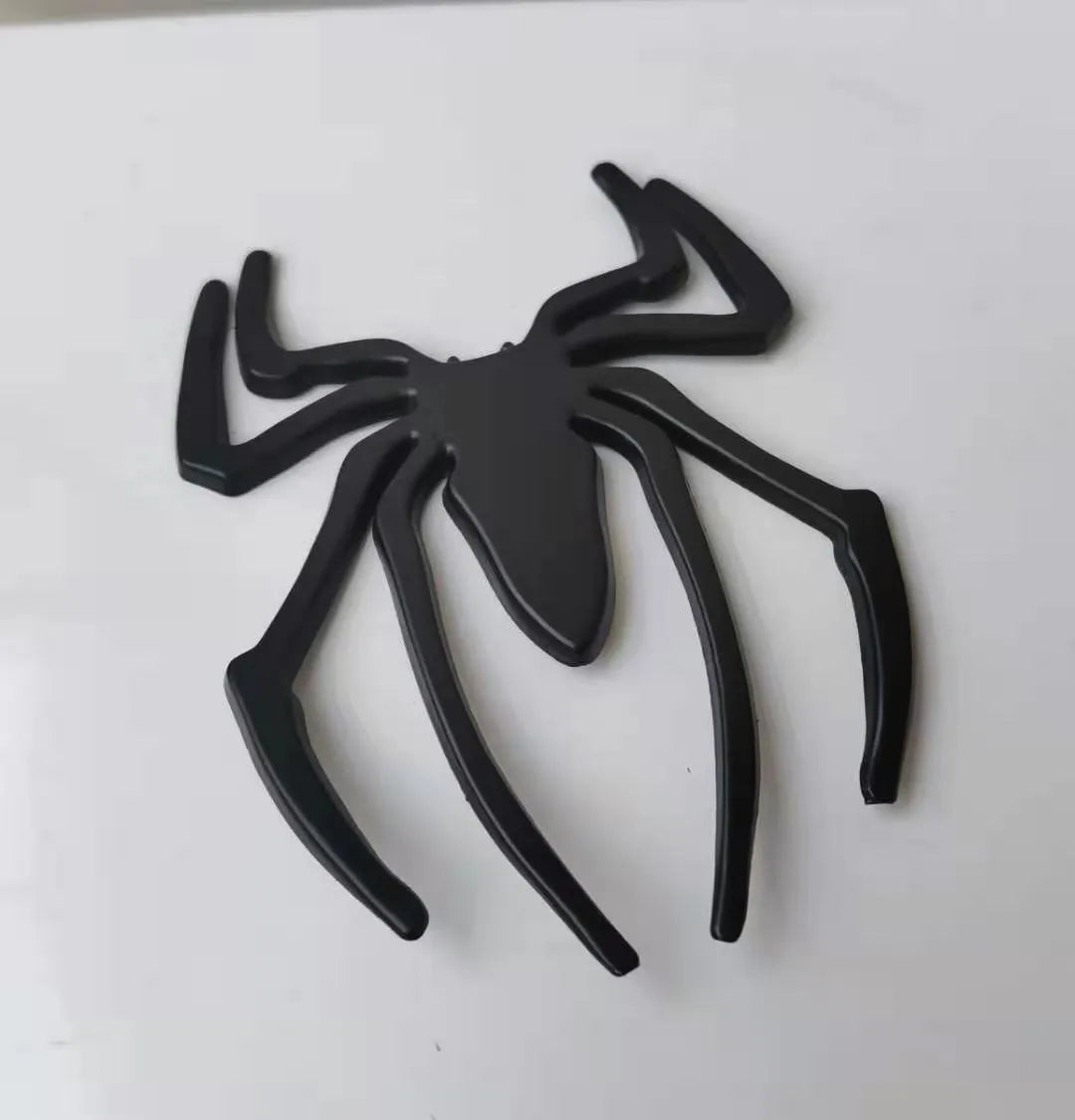 Three-dimensional metal spider bumper sticker in zinc alloy, showing gold colour option.