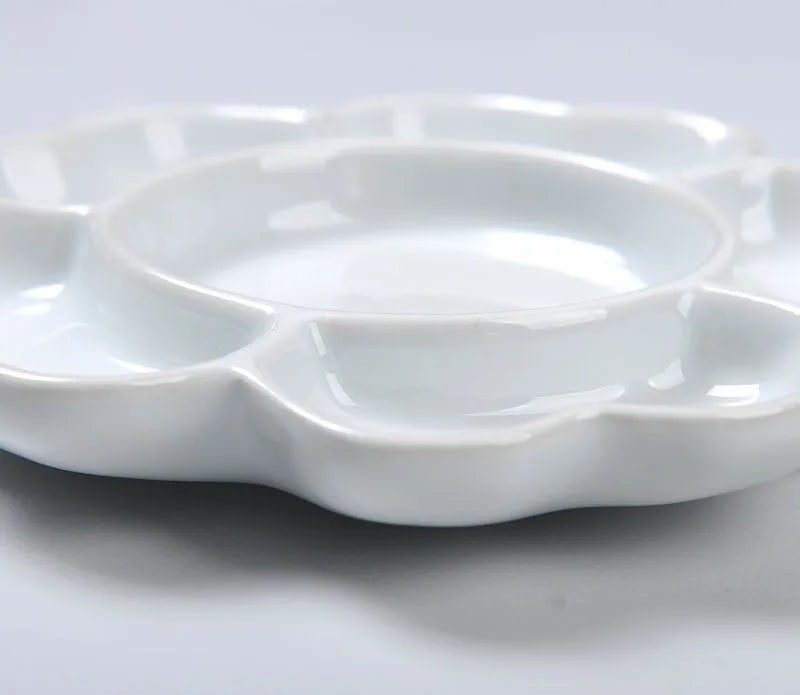 White handmade ceramic plum blossom shaped artist palette for painting.