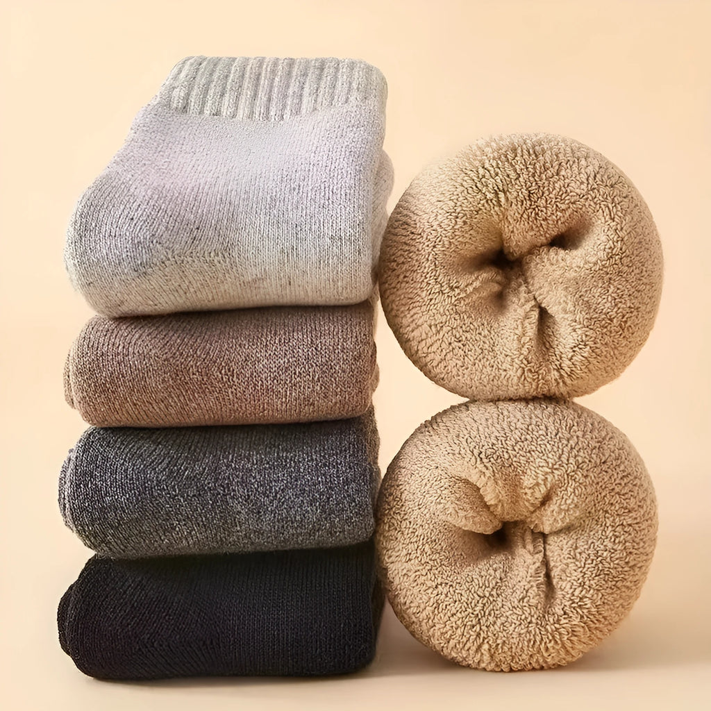 Two pairs of thick merino wool winter socks in solid colours showing midsole construction