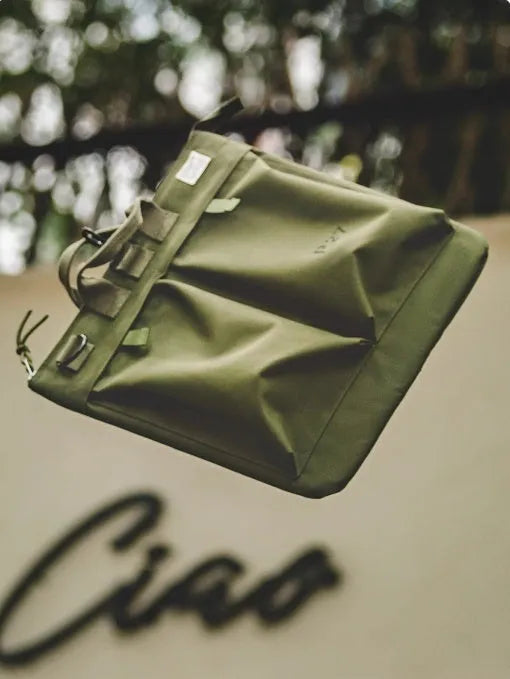 Military green canvas messenger bag with shoulder strap and zip closure showing internal phone pocket
