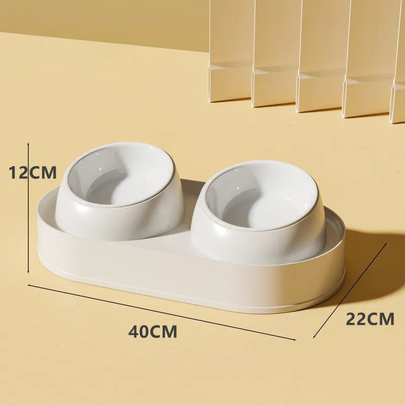 White elevated pet feeder with two tilted bowls on a stable plastic base, for cats and small dogs.