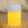 White cylindrical mini USB aromatherapy humidifier on a desk with charging cable.