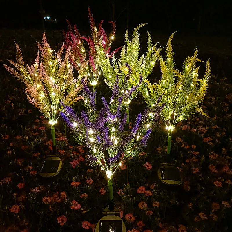 74cm tall pink lavender-shaped solar garden light with green stem, placed in a garden bed.