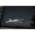 British reflective plastic bumper sticker shown in black, white and colourful variants, dimensions 16cm by 3.8cm.