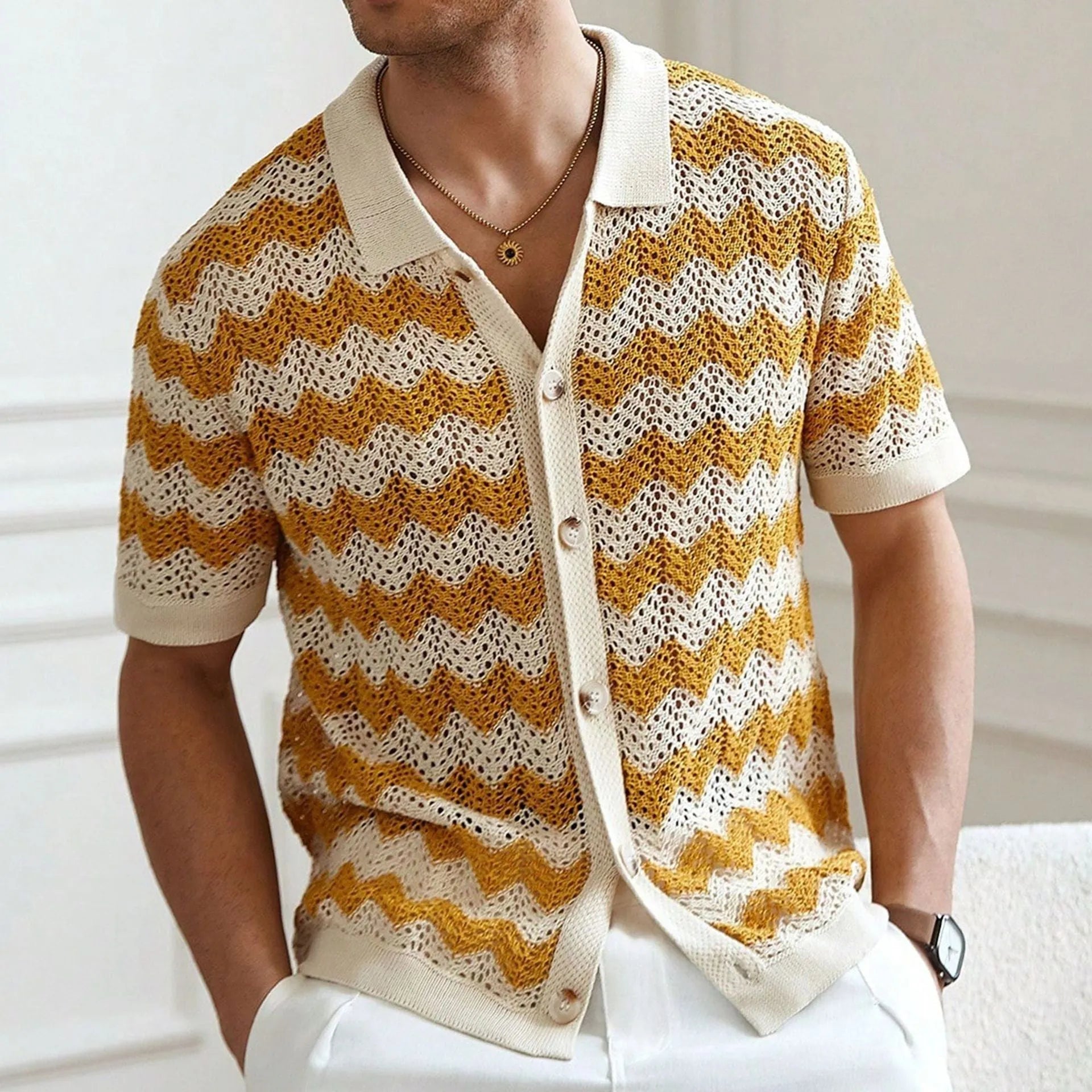Short-sleeved yellow corrugated knit sweater with flocking detail on a hanger.