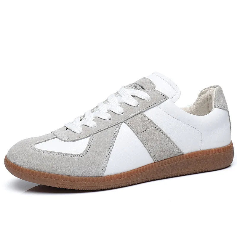 White low-top retro sneakers with mesh lining and rubber soles on a solid background