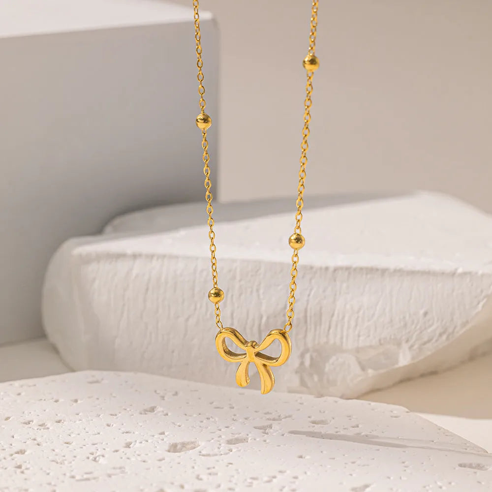 Gold electroplated bow necklace on cross chain with adjustable 41-50cm length