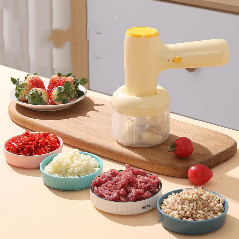Beige yellow USB rechargeable electric garlic chopper with 250ml cup and 304 blade on a kitchen counter