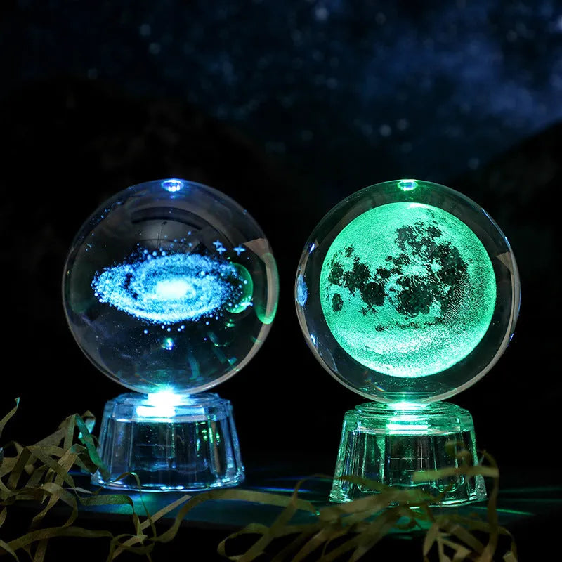 6cm transparent crystal ball ornament with illuminated inner carving of celestial designs on a table