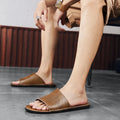 Men's brown and black leather casual sandals with rubber soles on size chart background