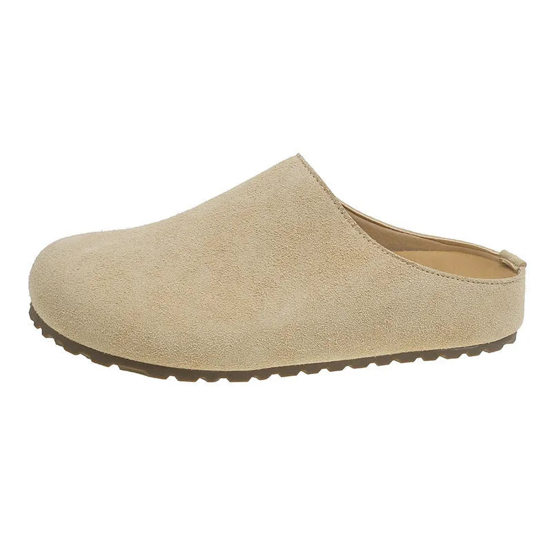A pair of soft, flat apricot-coloured slip-on slippers with a square toe and microfiber upper on a plain background.