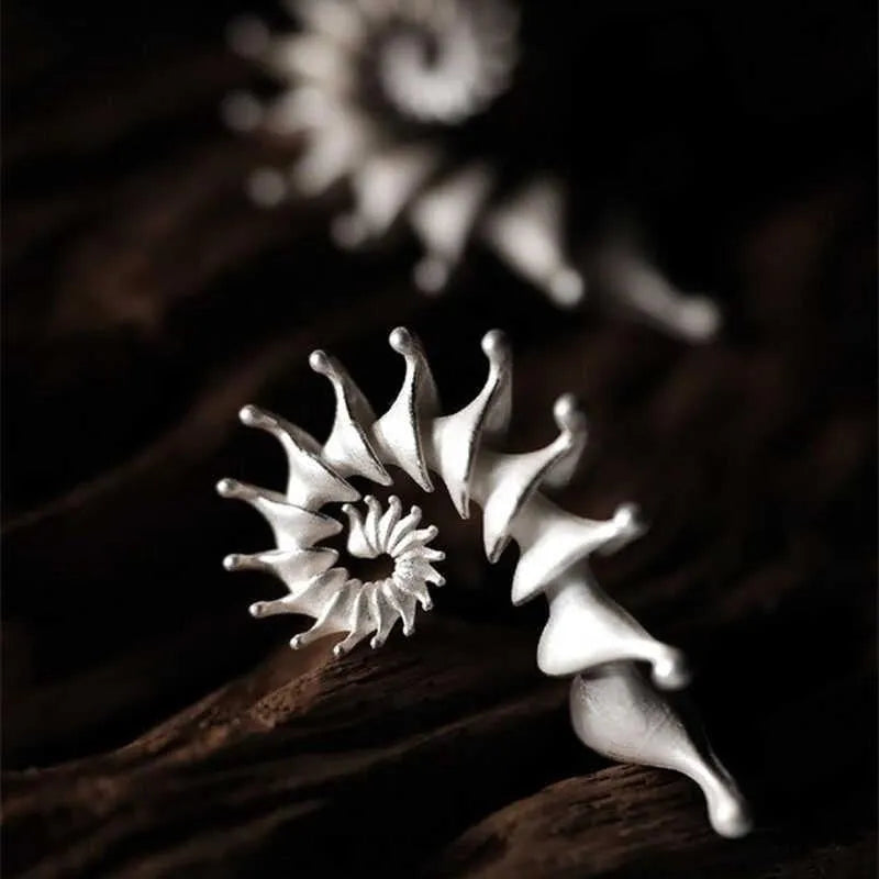 Exaggerated three-dimensional matte conch stud earrings with an irregular alloy design.