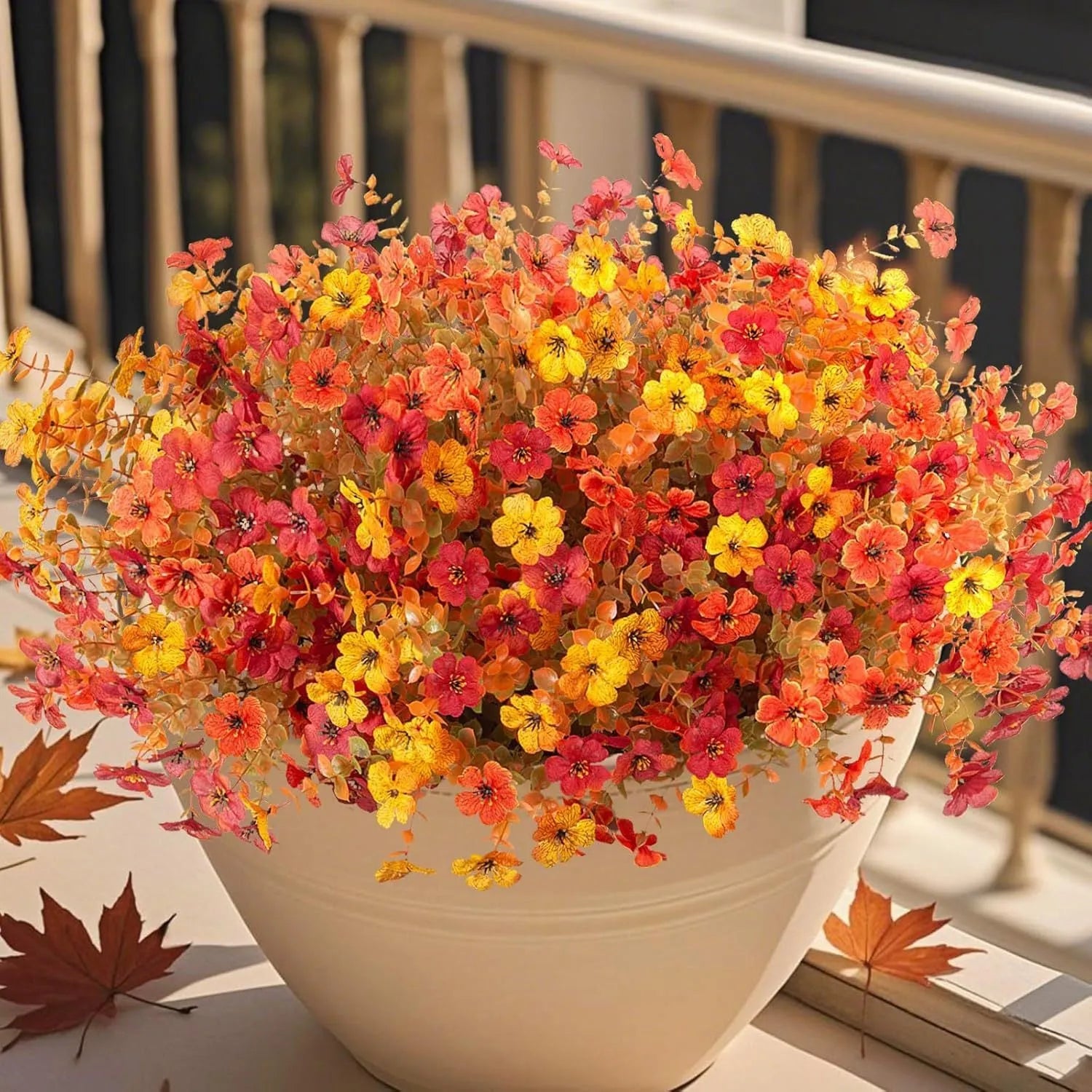 Plastic and silk artificial flower bouquet in autumn colours of red, yellow, orange and orange-yellow.