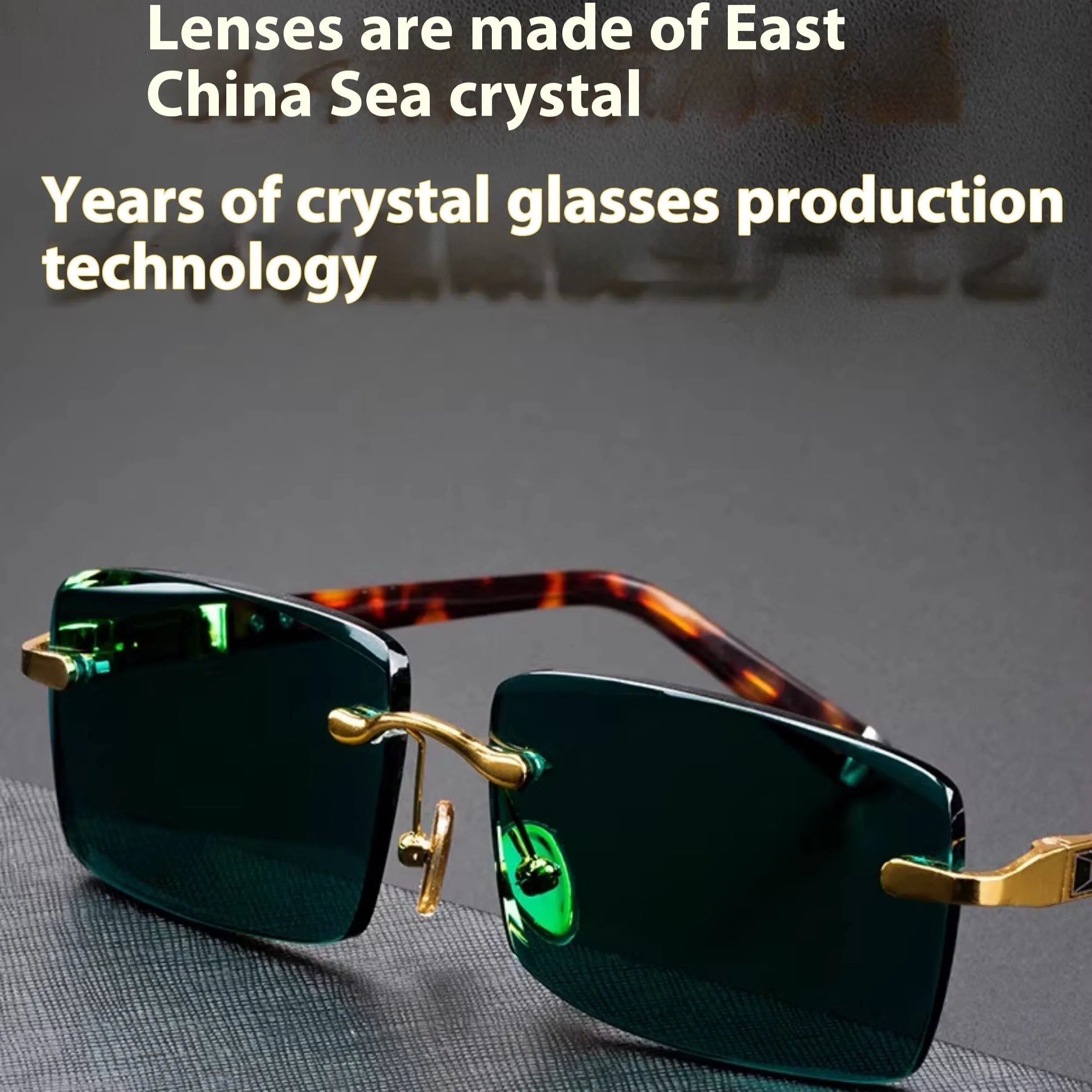 Dark green frameless crystal sunglasses with a matching case and cleaning cloth on a table.