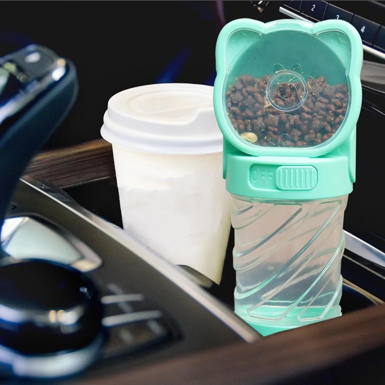 Green 3-in-1 portable pet water bottle with integrated food container and waste bag dispenser on a strap.