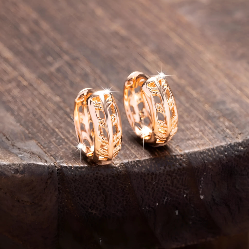 Small copper earrings with hollowed-out leaf and heart shapes in rose gold colour.
