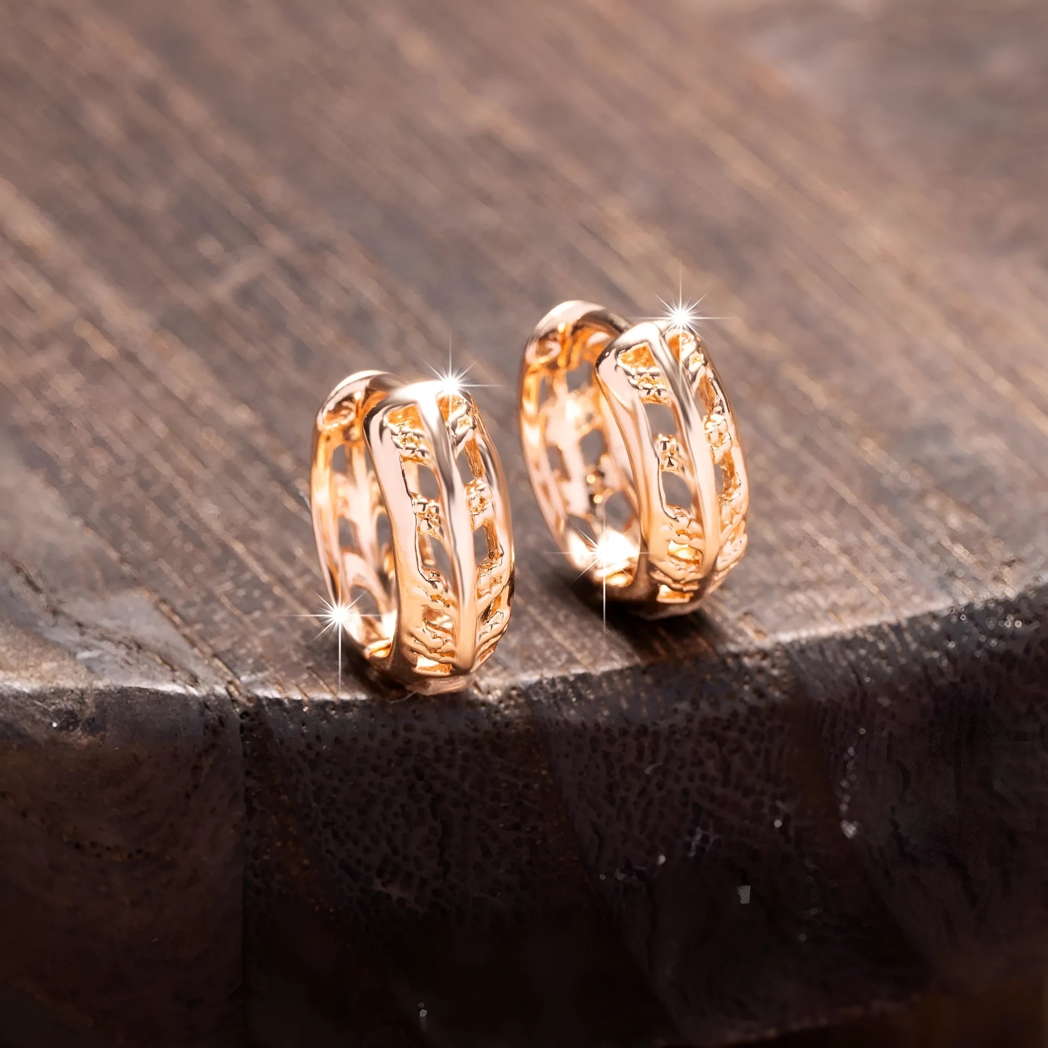 Small copper earrings with hollowed-out leaf and heart shapes in rose gold colour.