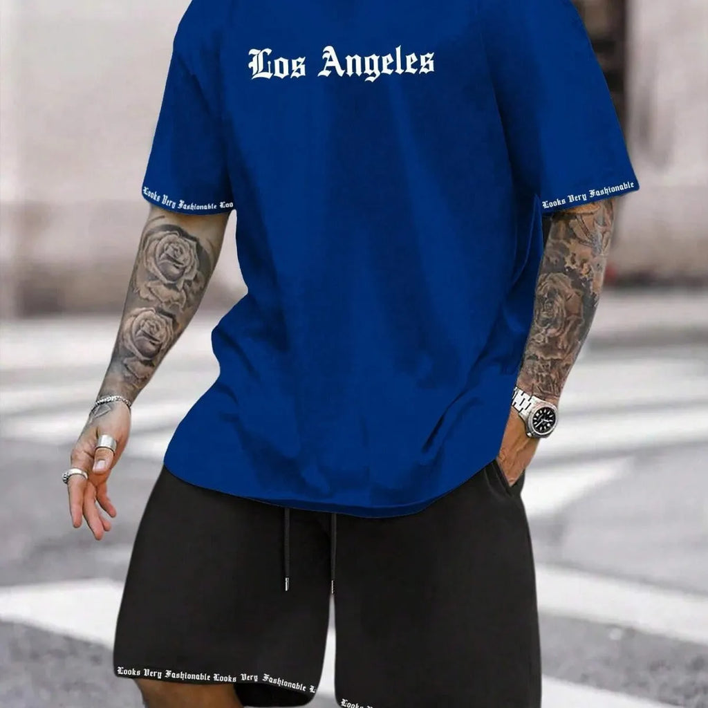 Man wearing a blue printed short-sleeve top and matching shorts from a two-piece sports casual set.