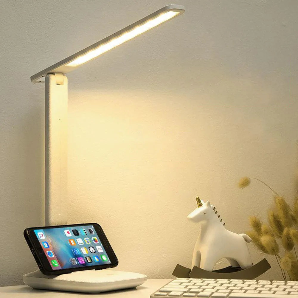 White plastic USB rechargeable bedside lamp with touch dimming control on a wooden surface.
