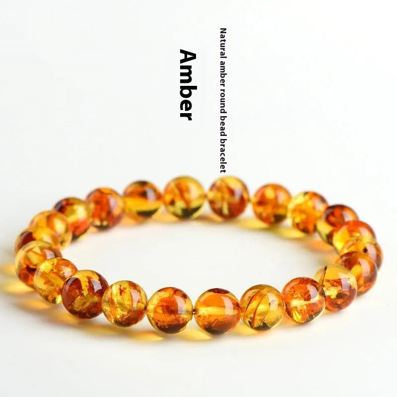 Natural yellow piebald amber bracelet with geometric beads on wrist.