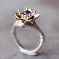 Silver two-tone women's ring with geometric shape and floral detailing on a hand.