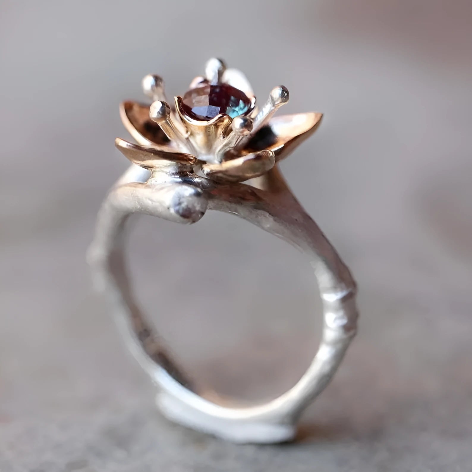Silver two-tone women's ring with geometric shape and floral detailing on a hand.