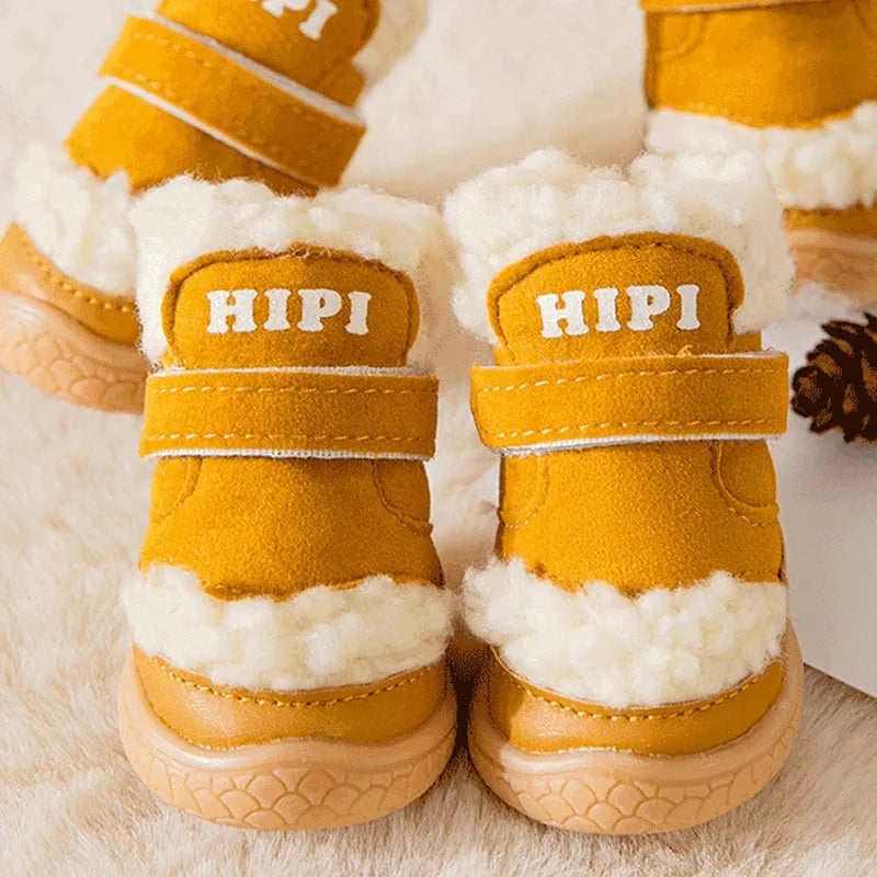 Brown winter dog shoes with adjustable Velcro straps and anti-slip rubber soles on a snowy surface