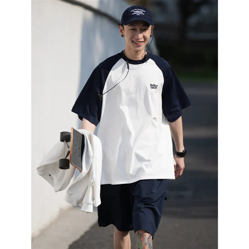 Blue casual men's t-shirt with raglan sleeves on a hanger, showing loose fit.