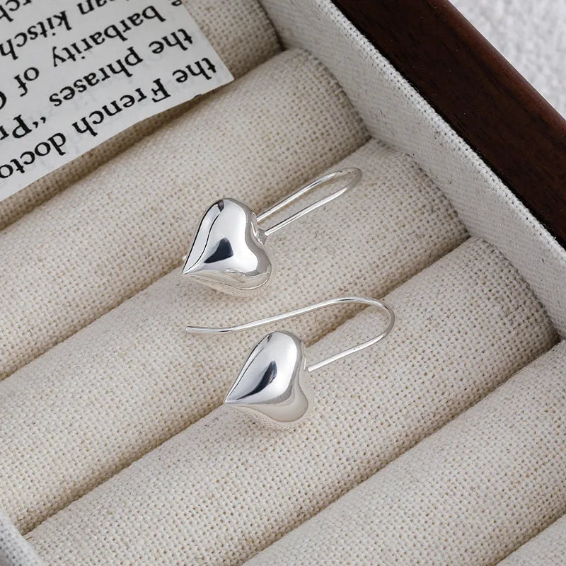 Silver heart-shaped earrings with glossy finish and ear hook fitting