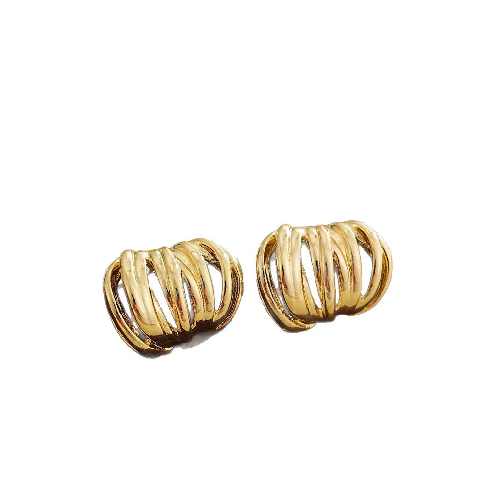 Gold metal ear loops with niche design and metal earrings on white background