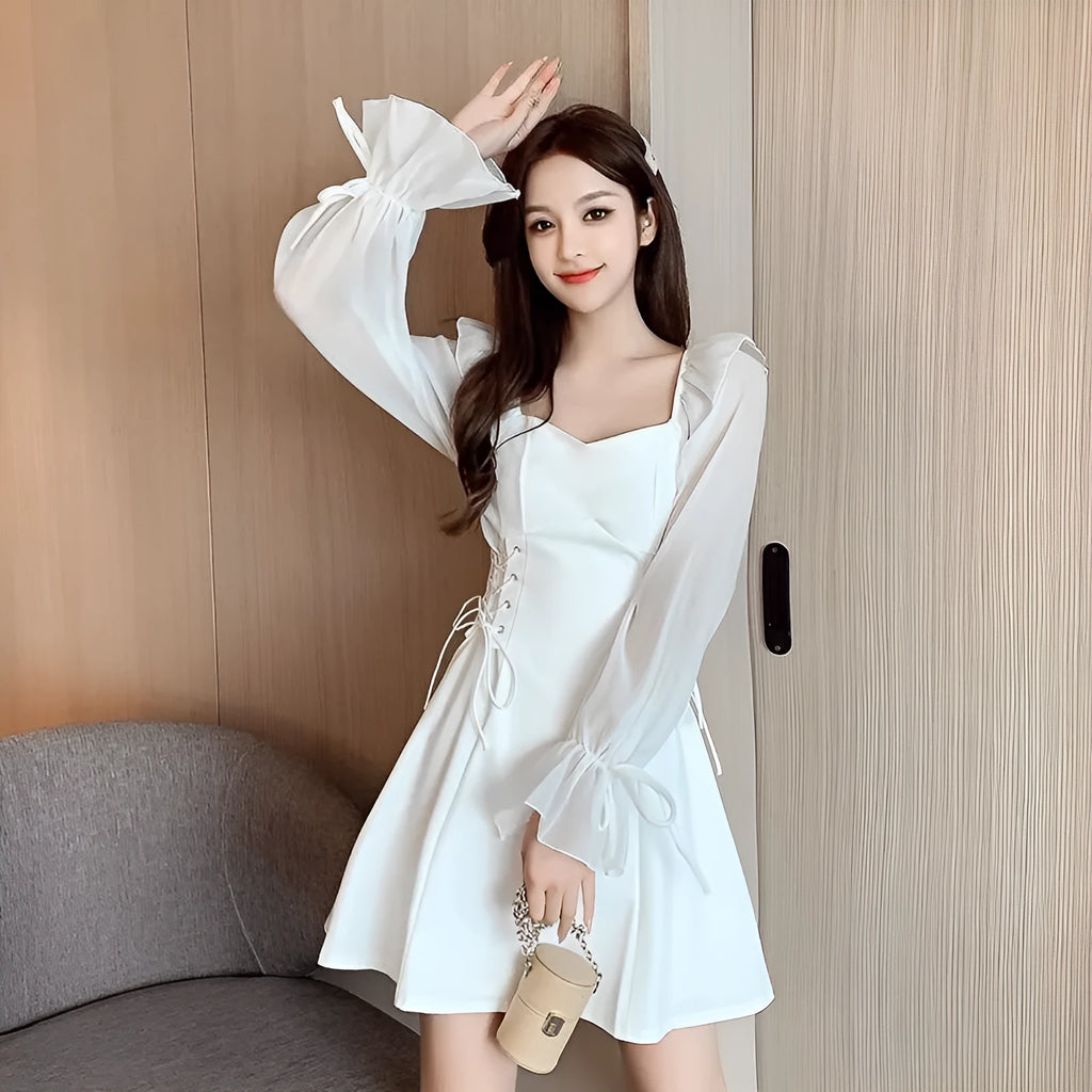 White chiffon patchwork dress with long sleeves and a waist-slimming silhouette on a hanger.