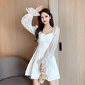 White chiffon patchwork dress with long sleeves and a waist-slimming silhouette on a hanger.