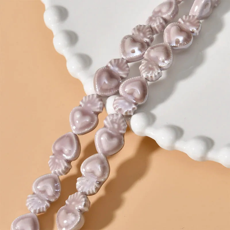 Ceramic love heart torch beads in multiple colours showing 10x15mm size and straight hole design