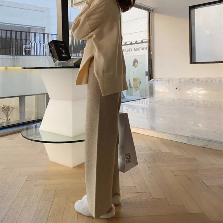 Women's high-waist knitted wide-leg trousers in cream white, showing straight-leg cut and drooping hem.