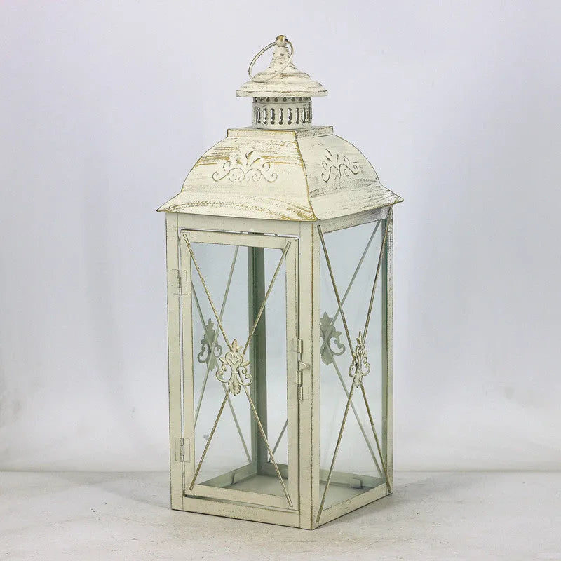 Black and white wrought iron floor-standing storm lantern with tempered glass panels in three sizes for courtyards.
