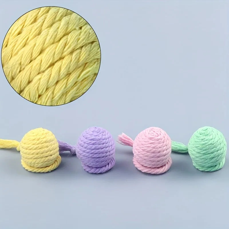 Cat toy ball with rope attached in green, pink, purple, or yellow colours with internal bell