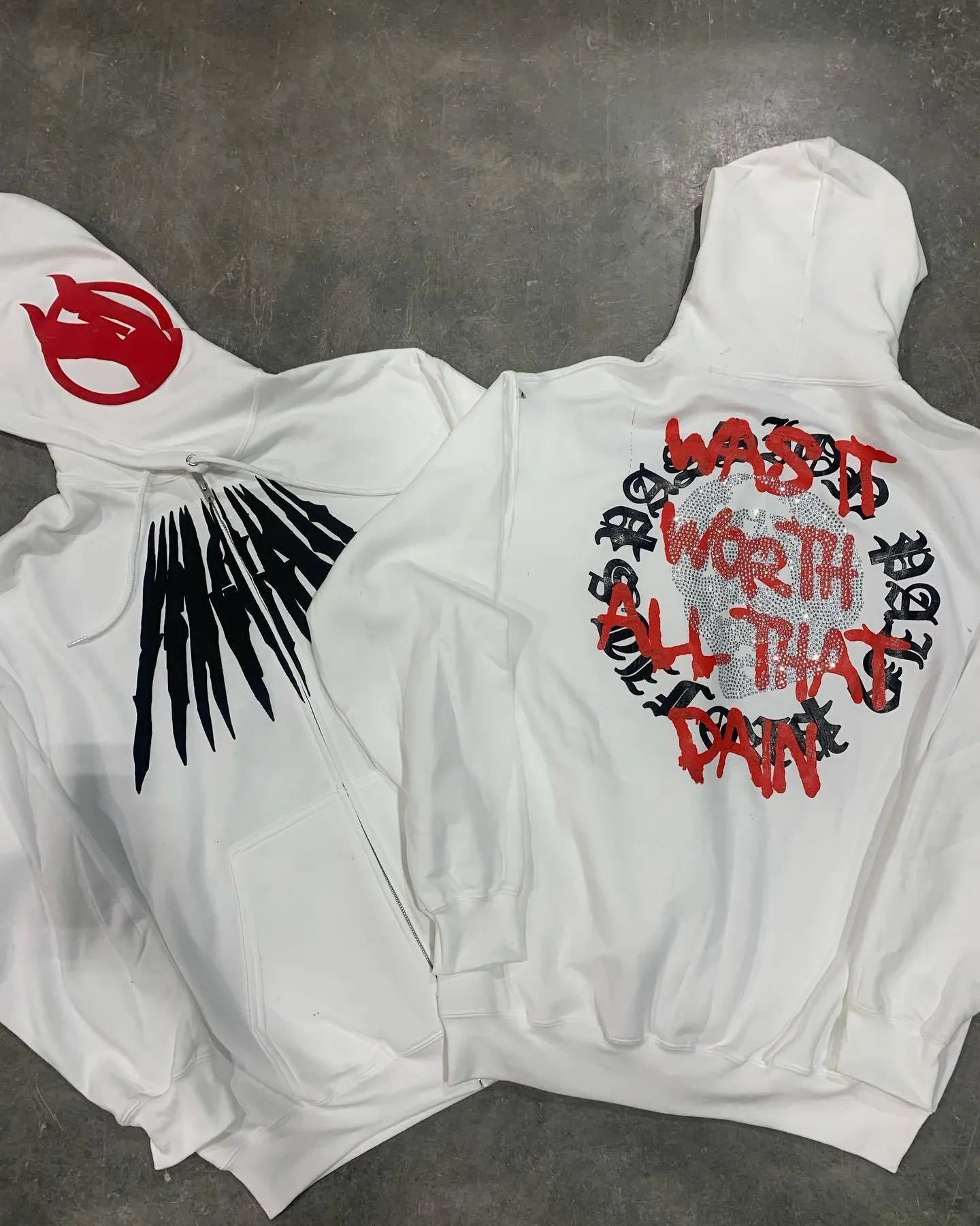 Black loose hooded sweatshirt with white printed skull and rhinestone detail, cardigan style.