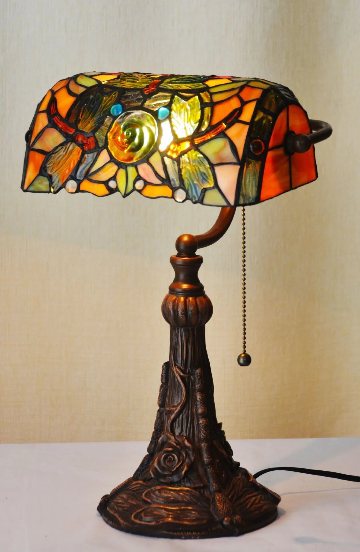 10-inch tall Tiffany table lamp with multi-coloured stained glass shade on a resin base.