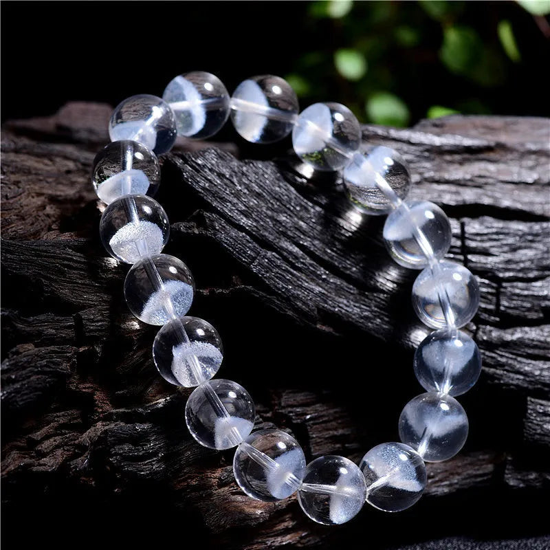 Women's white crystal bracelet with ghost pyramid beads and a ruyi charm, shown on a wrist.