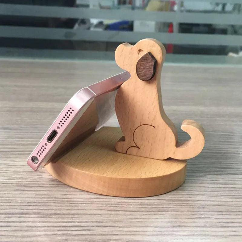Resin decorative mobile phone holder bracket in an animal design on a wooden desk.